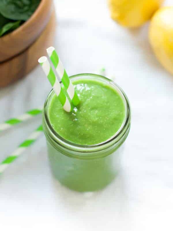 overhead view of a green smoothie in a mason jar with a straw