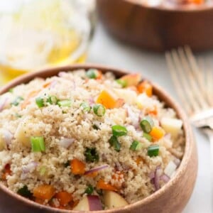 Close up of a couscous salad on a wooden bowl.