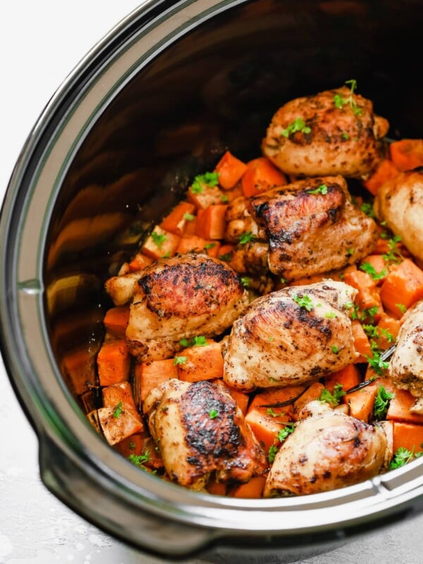 overhead view of a slow cooker pot containing sweet potato and chicken