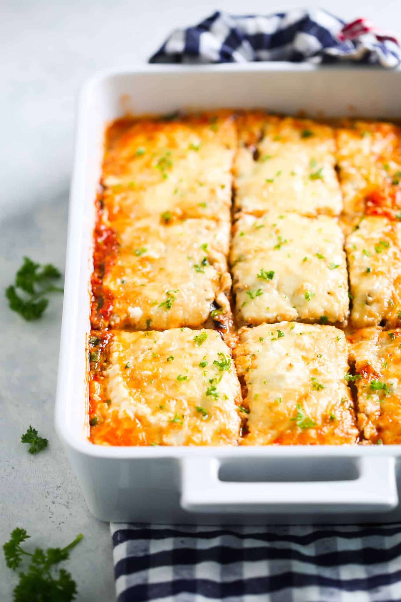 Low-Carb Eggplant Lasagna - This Low-Carb Eggplant Lasagna recipe is made with eggplant slices, which makes it perfect for those who are following a low-carb and gluten-free diet. It's absolutely delicious too! eggplant lasagna in a large, white baking dish.
