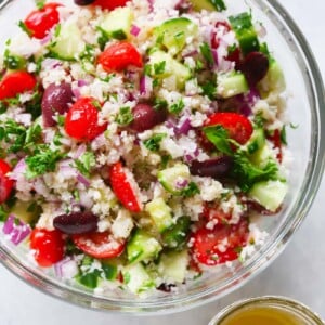A glass bowl containing cauliflower mediterranean salad.
