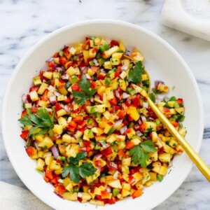 overhead view of a white bowl with peach salsa