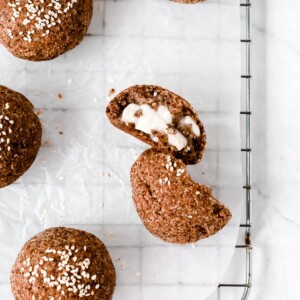 Overhead photo of a dinner roll cut opened on a cooling rack.