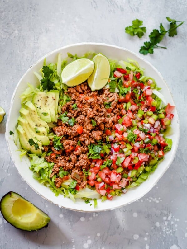 An overhead photo of a white plate of ground beef taco salad.