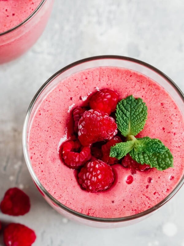 overhead view of a low carb raspberry smoothie garnished with fresh berries and mint