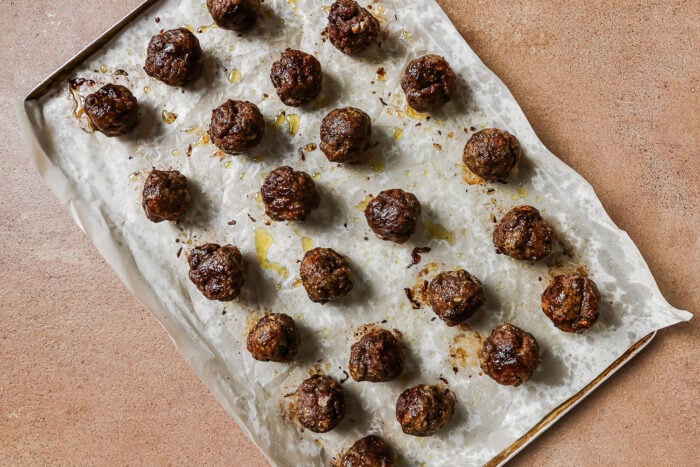 baked meatballs on a baking sheet.
