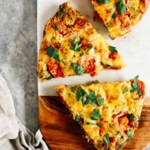 vegetable frittata cut into pieces on a wooden serving board