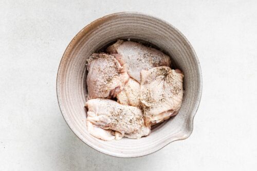 seasoned chicken thighs inside of a bowl