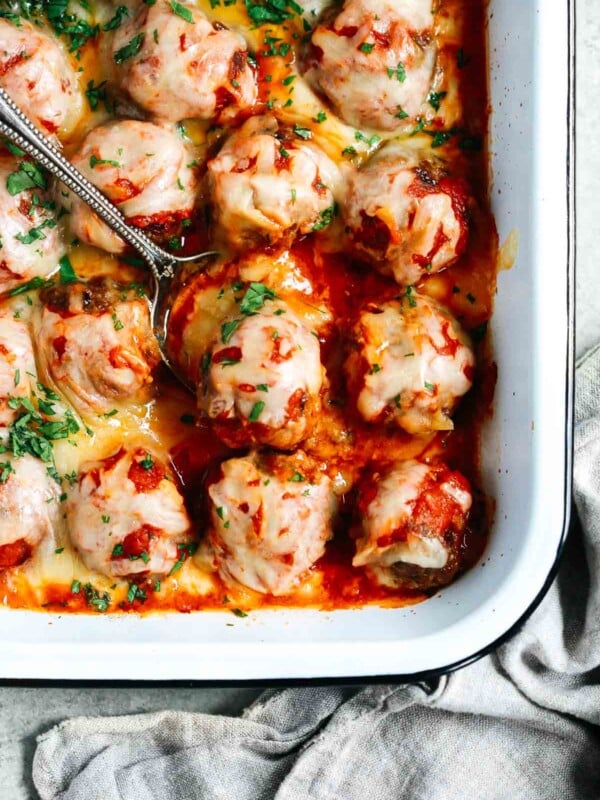 Close up of Baked Meatballs Casserole with a spoon lifting one meatball