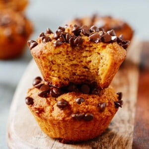 A close up of pumpkin chocolate chip muffins on a serving board