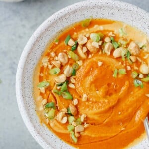 Spicy carrot soup in a speckled bowl.