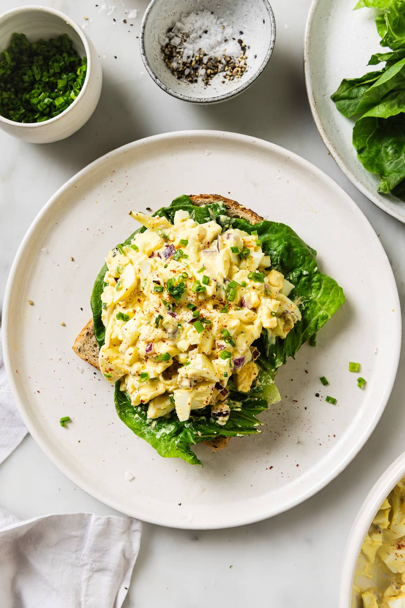 egg salad on a white plate on a marble countertop