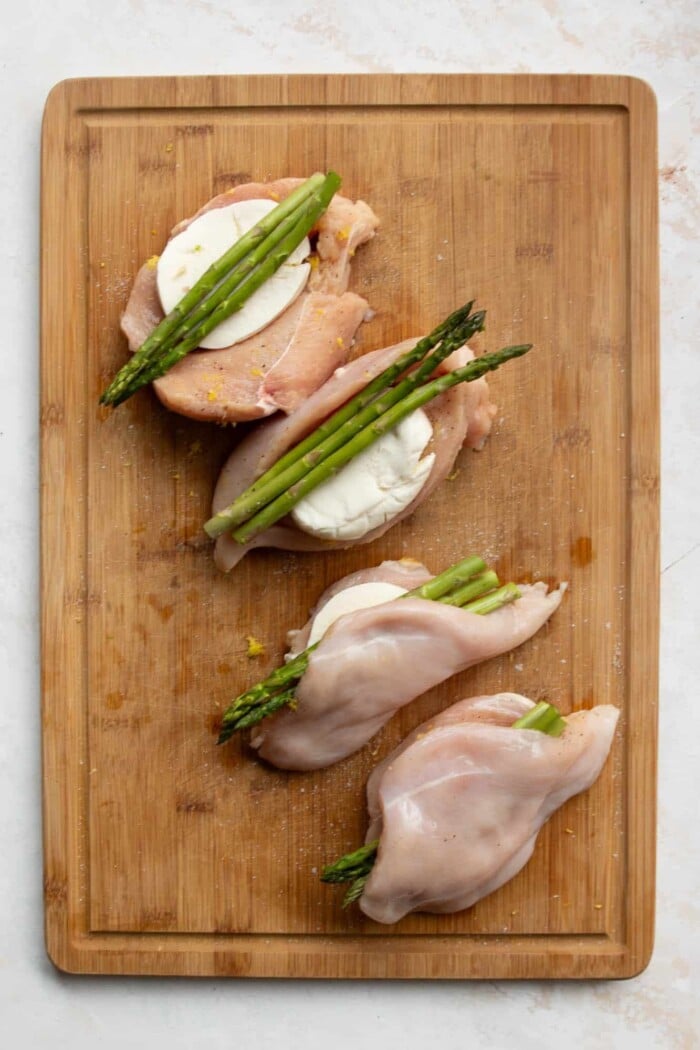 Asparagus stuffed chicken breast on a wooden board