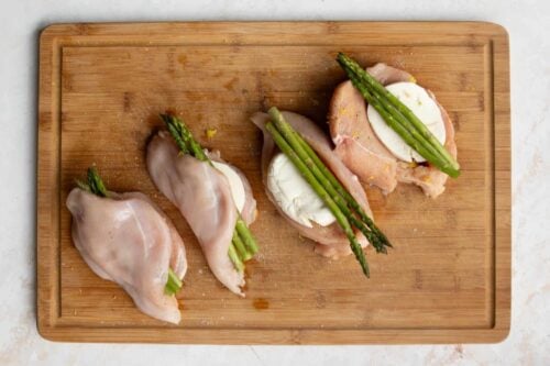 Asparagus stuffed chicken breast on a wooden board