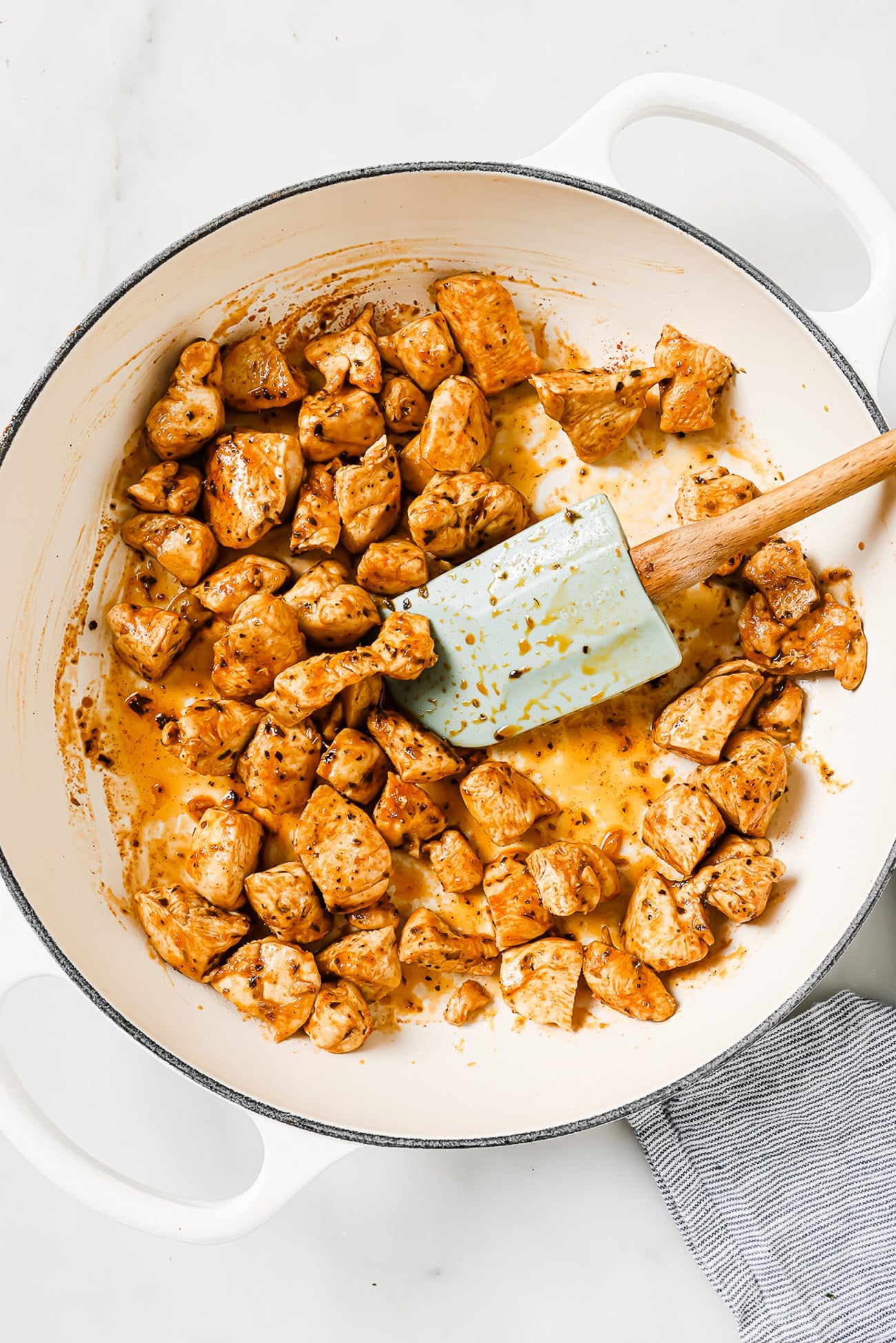 cubed chicken in a white skillet