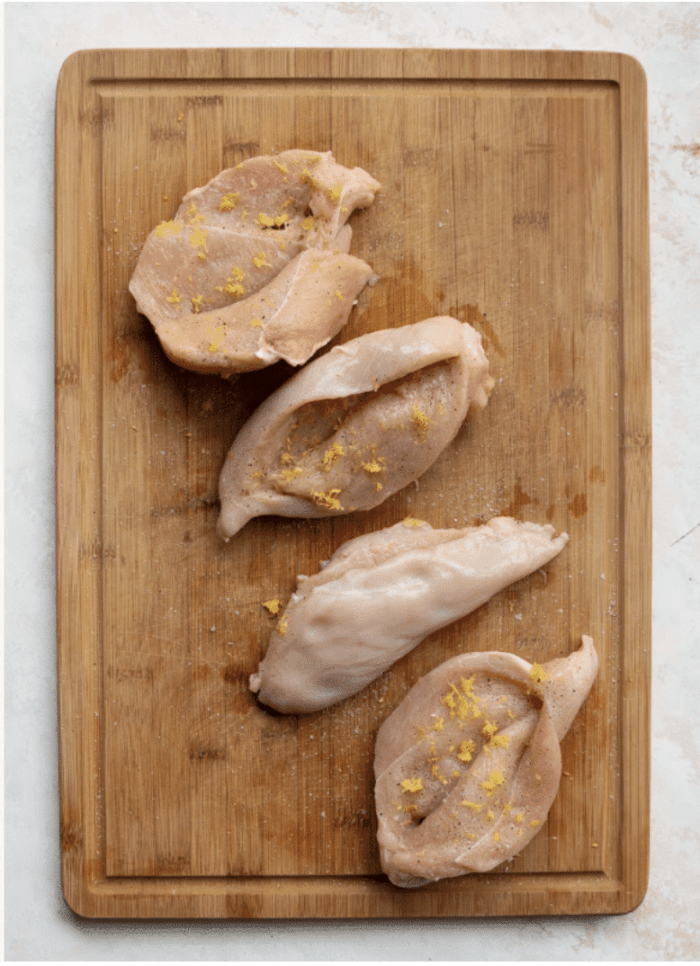 raw chicken breast on wooden board