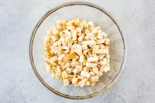 overhead view of a glass bowl containing chopped bread