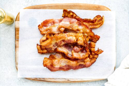 overhead view of cooked bacon on a white surface