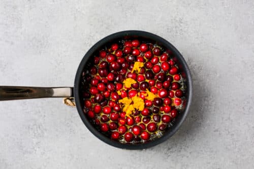 overhead view of cranberries and orange juice in a pan