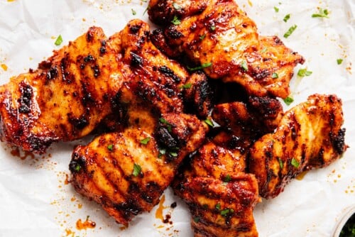 grilled chicken thighs on a parchment paper on the counter top.