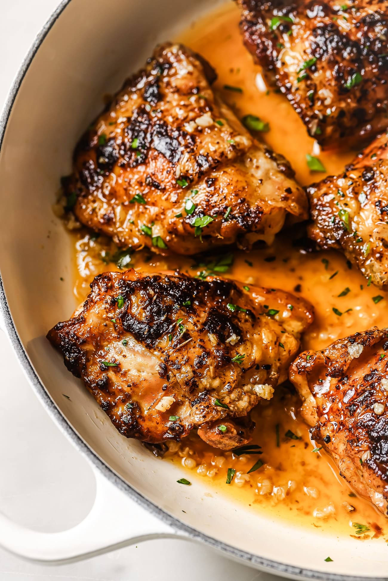 Close up of pan seared chicken thighs in a skillet.