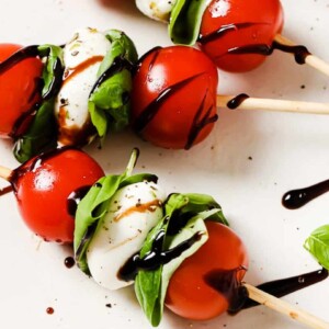 close up of caprese skewers on a white plate