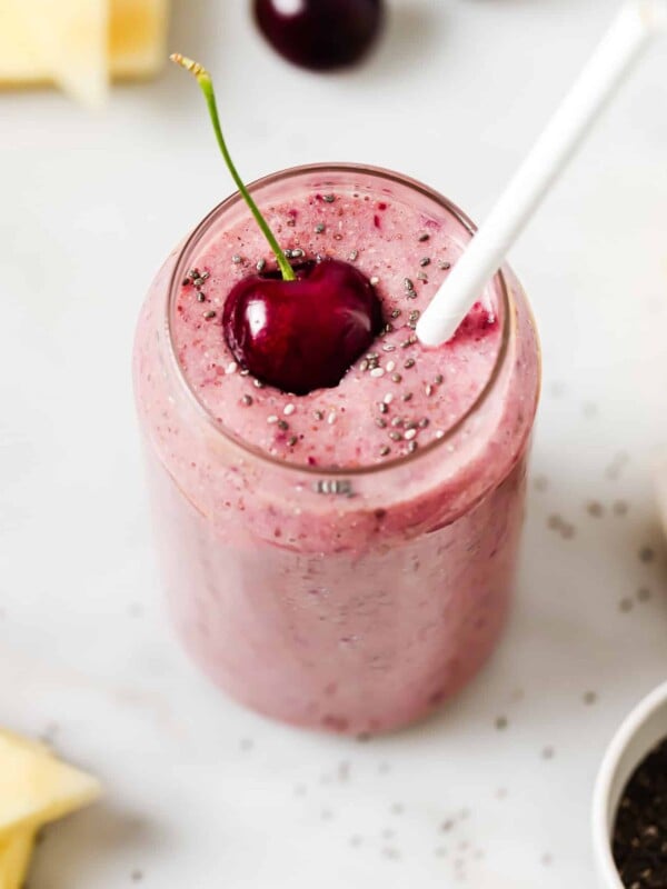 a glass of cherry smoothie on a countertop