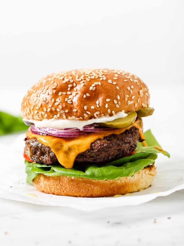 close up of a hamburger on a parchment paper.