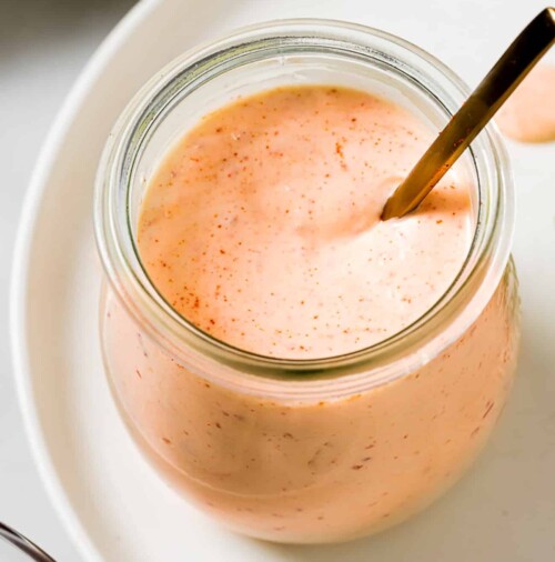 closeup view of chipotle sauce in a glass little jar.