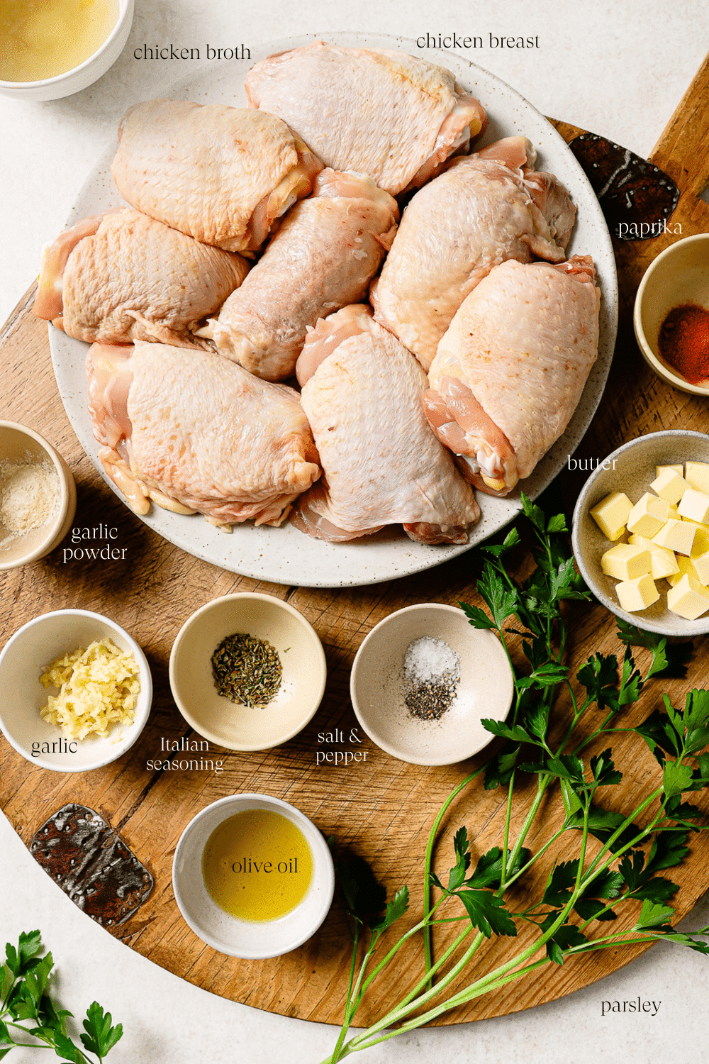 Pre-measured ingredients for slow cooker chicken thighs on a wooden cutting board.