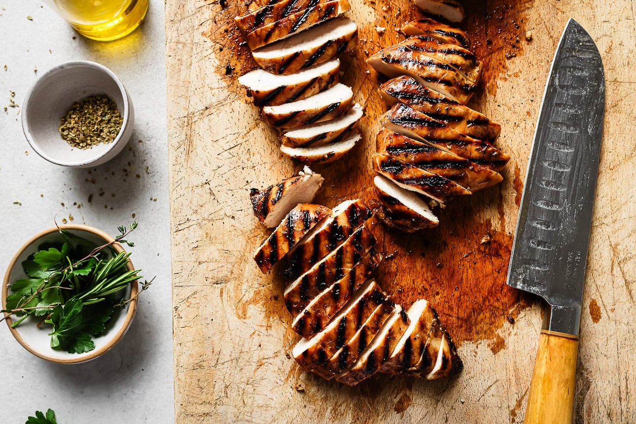 Grilled chicken breast on a wooden board.