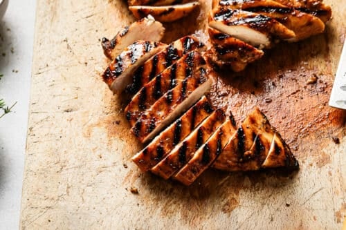 Grilled chicken breast on a wooden board.