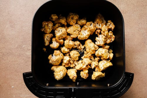 cauliflower florets in a air fryer basket