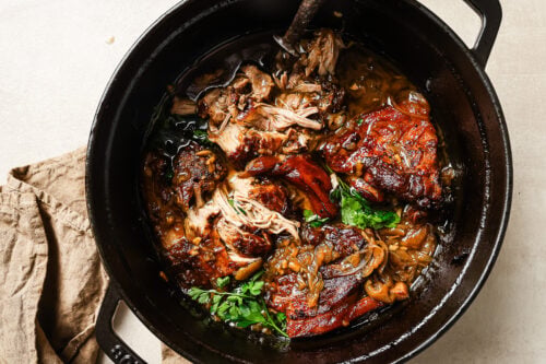 Close-up of Apple Cider Braised Pork Shoulder in a black Dutch oven.