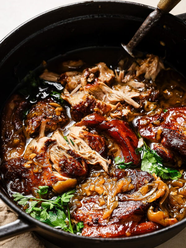 Close-up of Apple Cider Braised Pork Shoulder in a black Dutch oven.