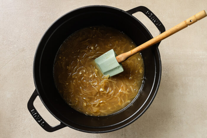 sauteed onions and apple cider in a Dutch oven pot.