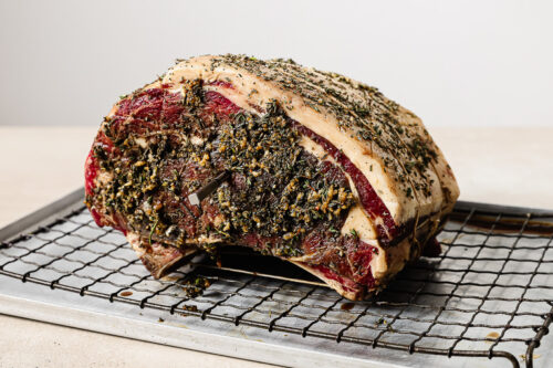 Thermometer inserted into a prime rib roast, ready to go in the oven for perfect reverse sear cooking.