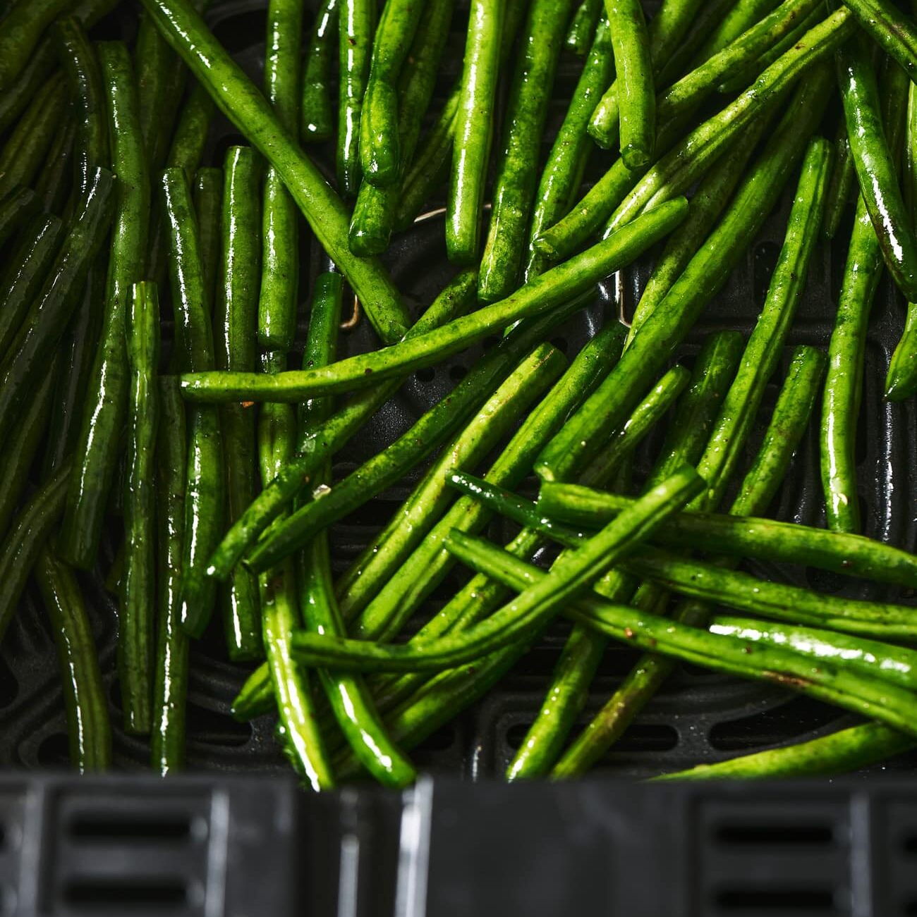 greens beans in an air fryer basket