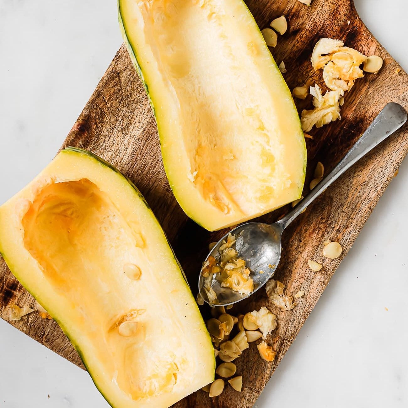 The seeds are scooped out of the squash halves.